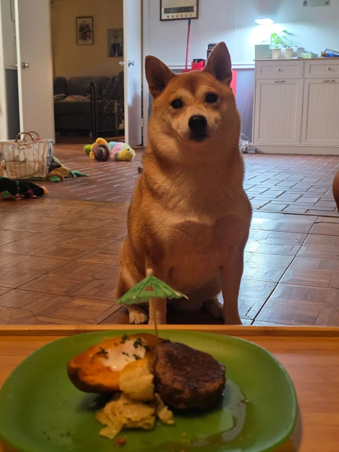 Kuku sitting proudly in front of her birthday plate, complete with a little paper umbrella